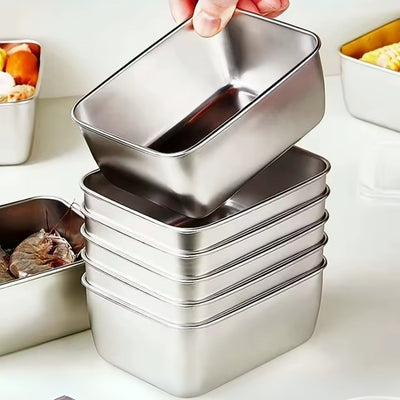 Stack of metal food containers with a hand lifting one, on a kitchen counter.
