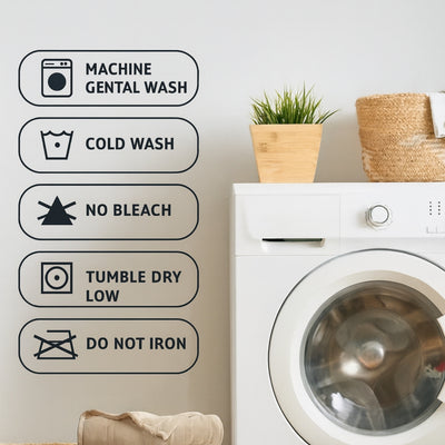 White washing machine with laundry care symbols on a light gray wall.