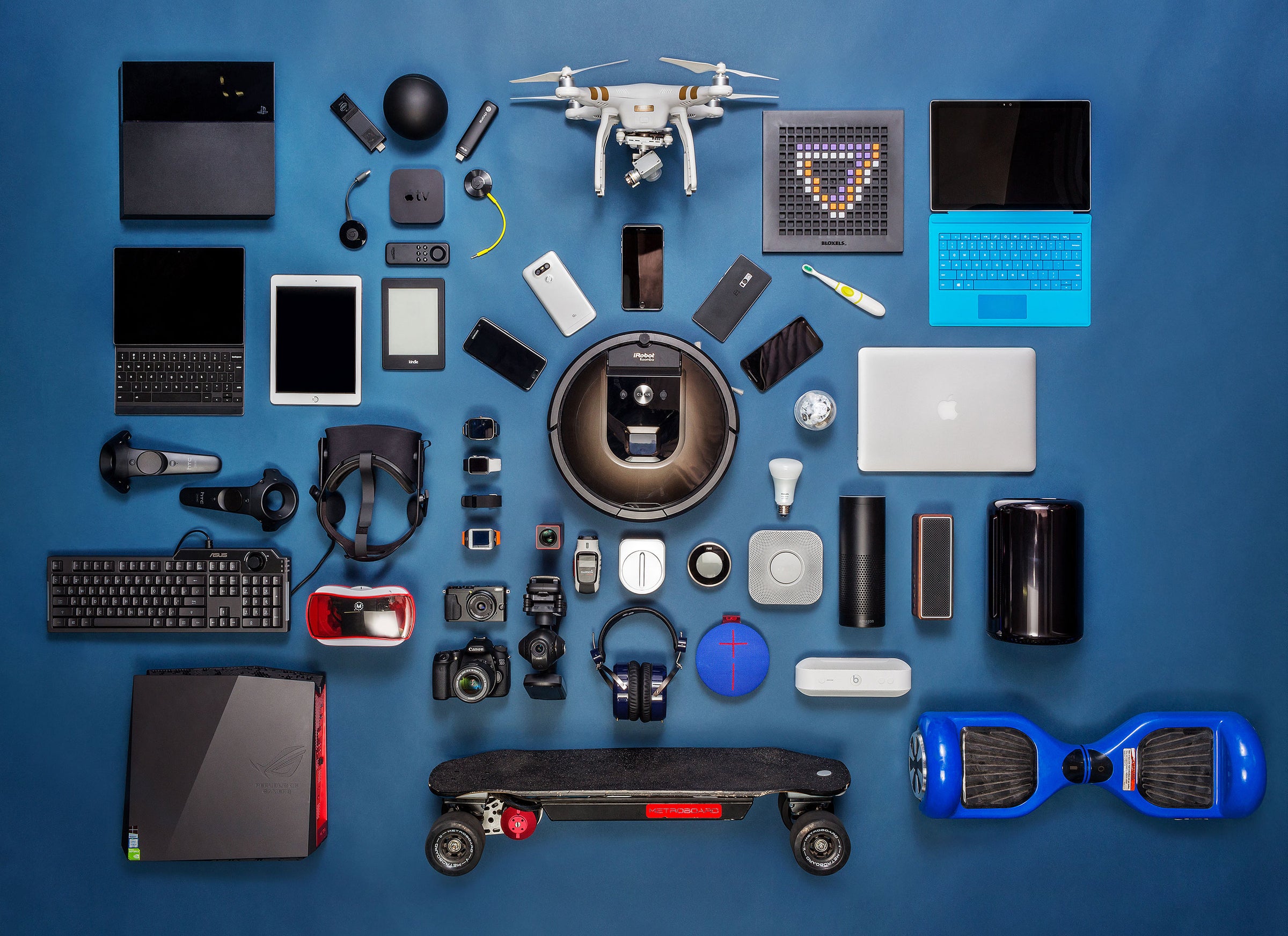 Collection of electronic devices and gadgets arranged on a blue background